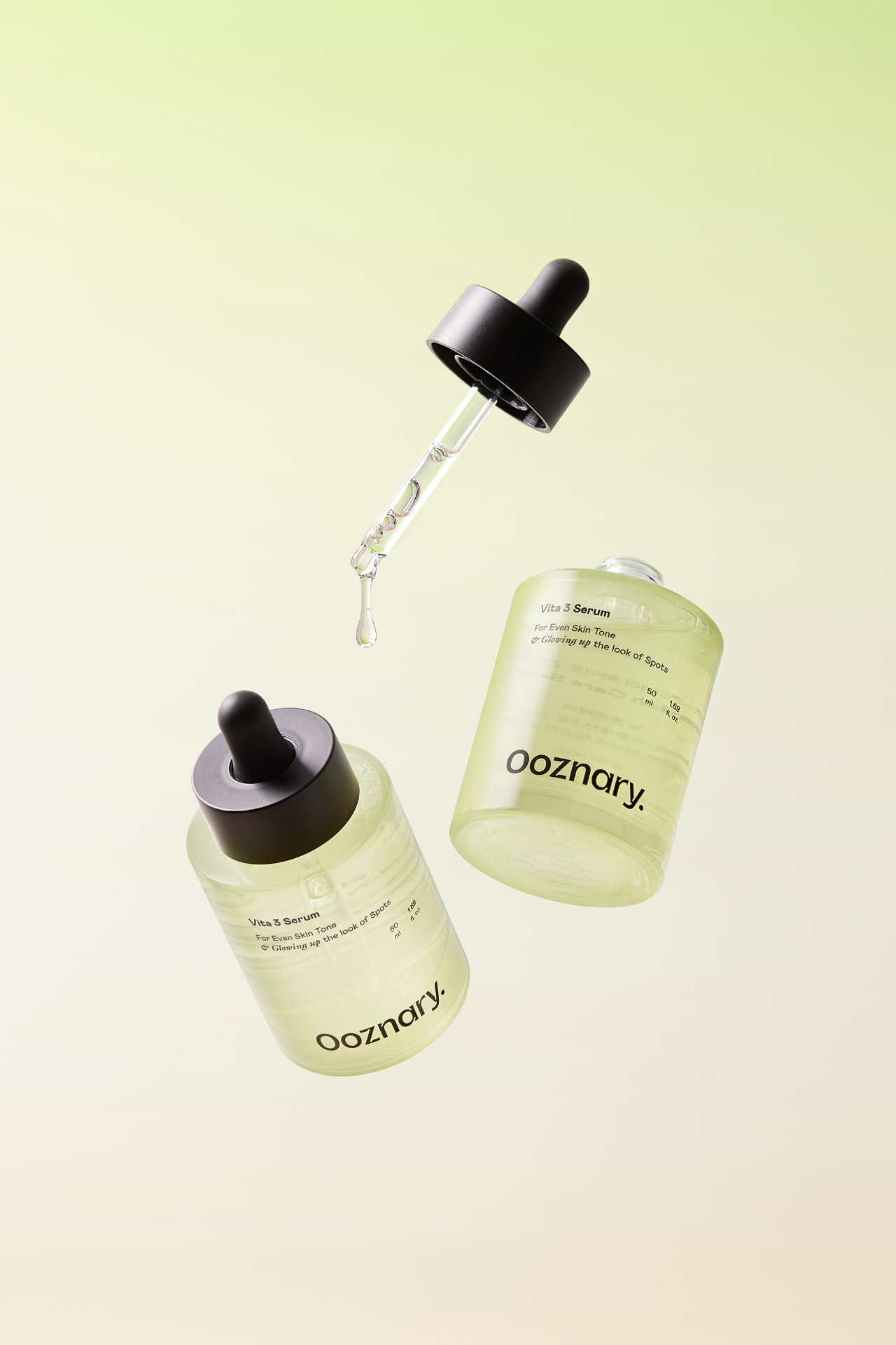 OOZNARY Vita 3 Serum bottles with dropper and a falling drop on a soft green backdrop
